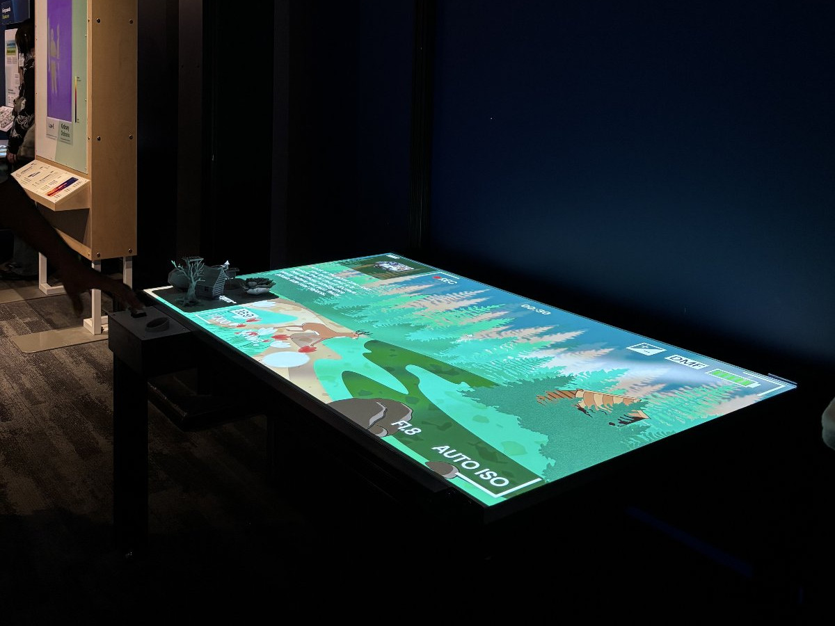 The FAST table installed on the Museum of Science floor — the forest scene glowing on the tabletop