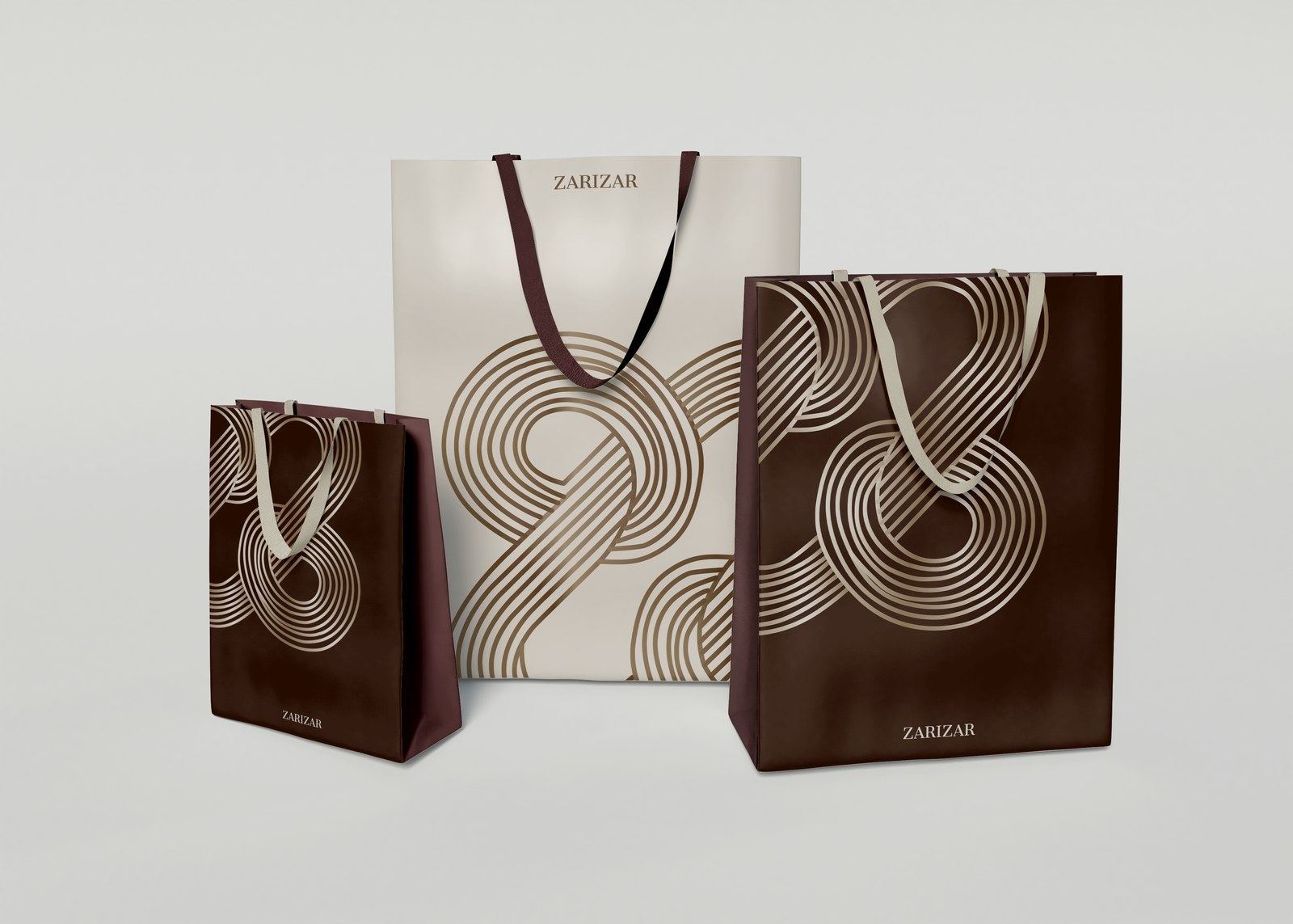 Three ZariZar shopping bags with cream and dark brown looping graphics